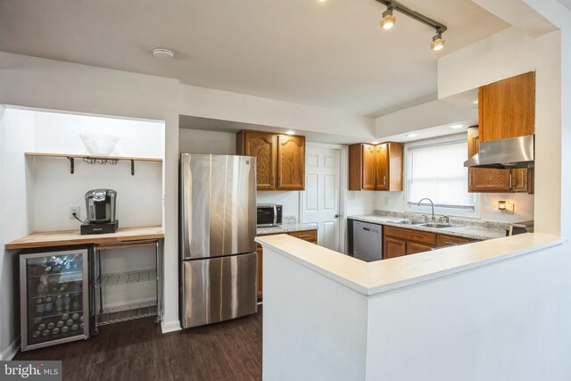 kitchen featuring wine cooler, dark wood-type flooring, sink, extractor fan, and appliances with stainless steel finishes