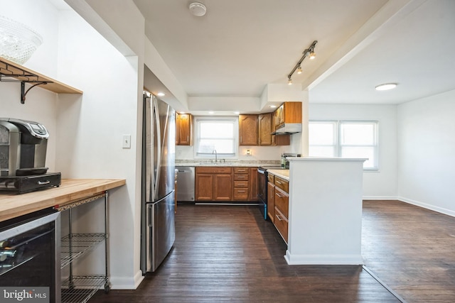 kitchen with sink, dark wood-type flooring, wooden counters, appliances with stainless steel finishes, and wine cooler