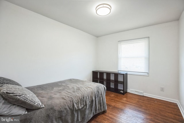 bedroom with dark wood-type flooring