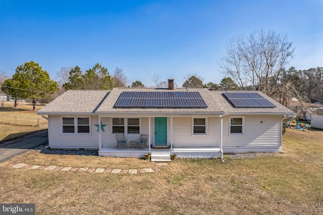 back of house with a yard, solar panels, and a porch