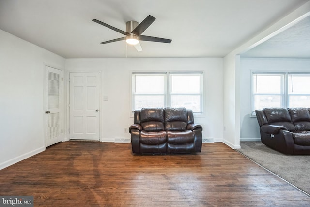 living area featuring dark hardwood / wood-style floors and ceiling fan