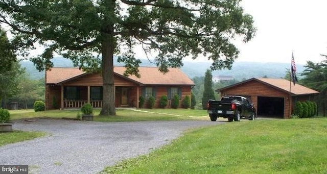 view of front of home with a garage, covered porch, and a front lawn