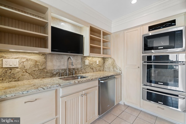 kitchen featuring stainless steel appliances, light tile patterned floors, sink, backsplash, and light stone counters