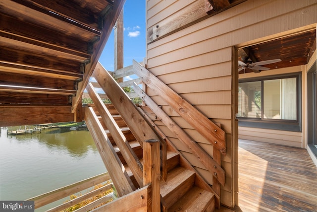 wooden terrace featuring ceiling fan and a water view