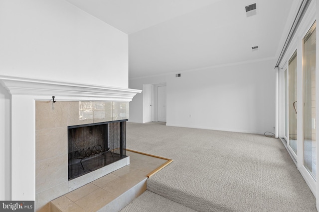 carpeted living room featuring a tile fireplace