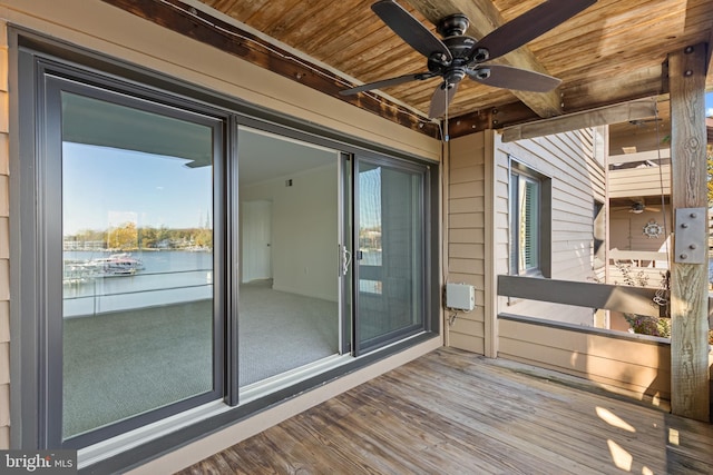 deck with ceiling fan and a water view