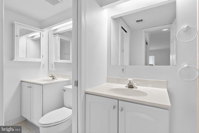 bathroom featuring toilet, vanity, and tile patterned flooring