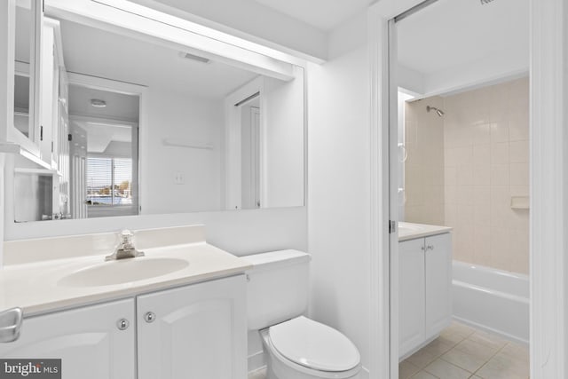 full bathroom featuring vanity, toilet, tiled shower / bath, and tile patterned flooring