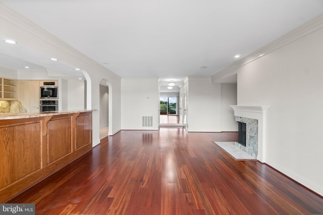 unfurnished living room featuring dark hardwood / wood-style floors, crown molding, and a premium fireplace