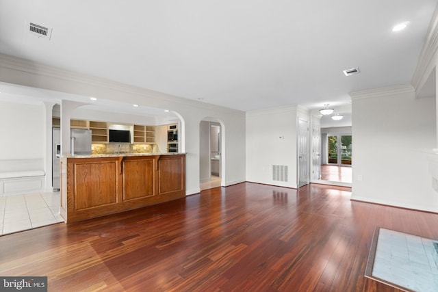 unfurnished living room with dark hardwood / wood-style flooring and ornamental molding