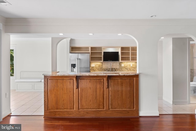 bar with crown molding, decorative backsplash, tile patterned flooring, and stainless steel fridge