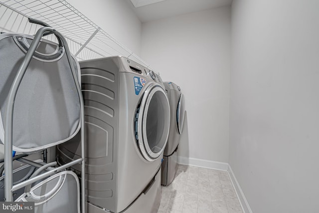 laundry area featuring washing machine and dryer, laundry area, and baseboards