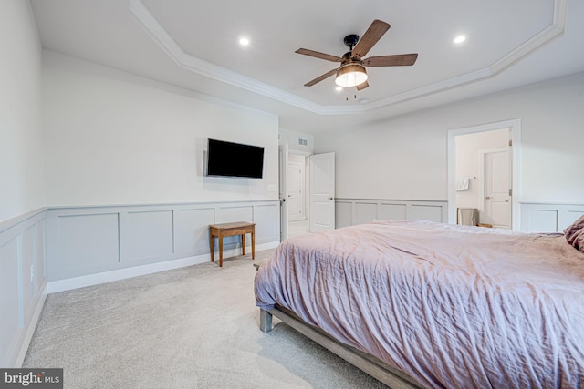 carpeted bedroom featuring ornamental molding, recessed lighting, a raised ceiling, and a decorative wall