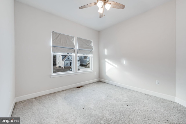 spare room with carpet floors, baseboards, visible vents, and ceiling fan