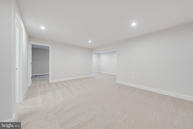 unfurnished room featuring recessed lighting, light carpet, and baseboards