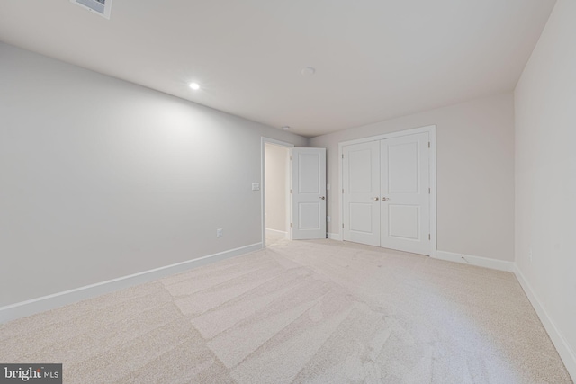 unfurnished bedroom featuring light carpet, visible vents, baseboards, a closet, and recessed lighting