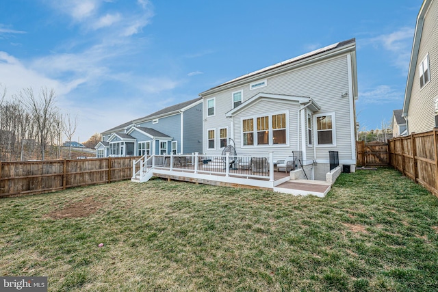 rear view of property with a fenced backyard, a yard, and a wooden deck