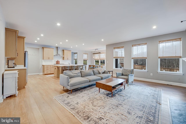 living room with baseboards, light wood-type flooring, and recessed lighting