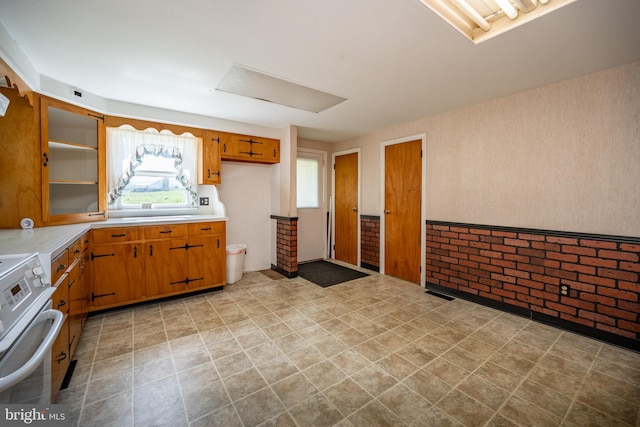 kitchen with electric range and brick wall