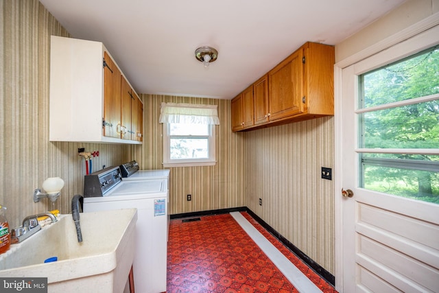 washroom with cabinets, sink, a wealth of natural light, and washing machine and clothes dryer