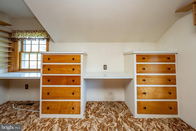 unfurnished bedroom featuring lofted ceiling and built in desk