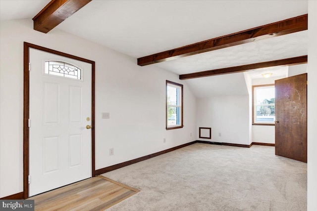 entrance foyer featuring light colored carpet and vaulted ceiling