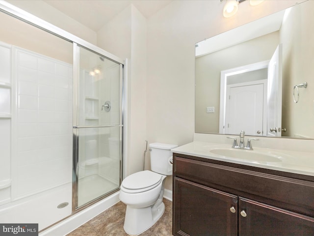 bathroom featuring vanity, a shower with door, and toilet