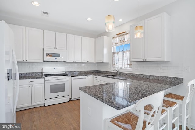 kitchen with pendant lighting, white cabinetry, sink, kitchen peninsula, and white appliances