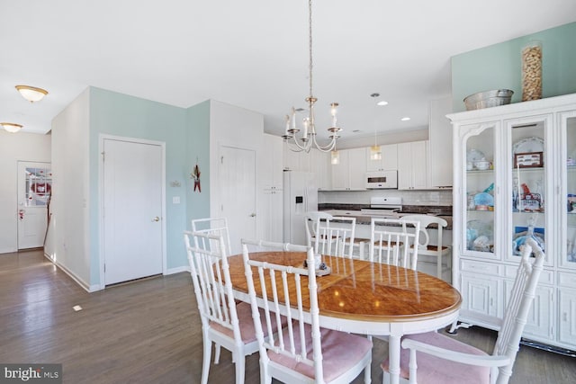 dining room with dark wood-type flooring and a notable chandelier