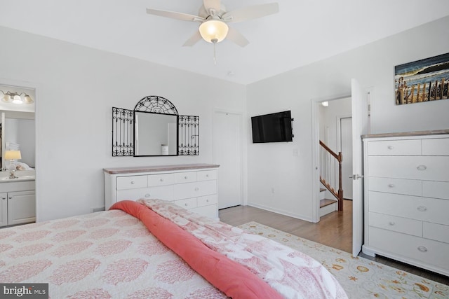 bedroom featuring ceiling fan, ensuite bath, and light hardwood / wood-style flooring