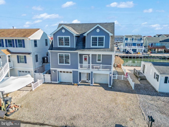 view of property with central AC unit, a garage, and a water view