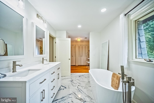 bathroom featuring a washtub and vanity