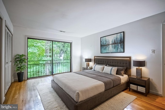 bedroom featuring access to exterior and light hardwood / wood-style flooring