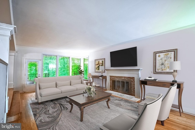 living room featuring a brick fireplace, light hardwood / wood-style floors, and crown molding