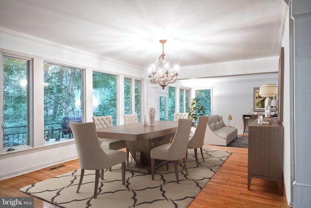 dining room featuring light hardwood / wood-style flooring, ornamental molding, and a chandelier