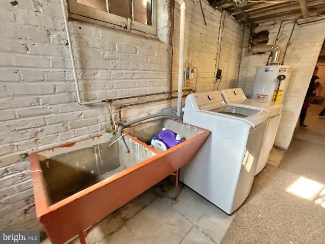 clothes washing area featuring washing machine and clothes dryer and water heater