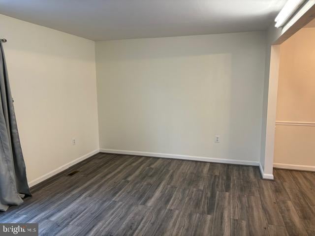 spare room featuring dark wood-type flooring