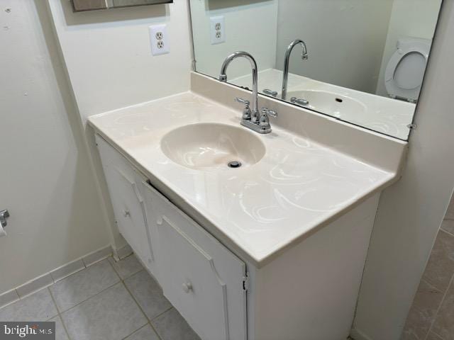 bathroom featuring vanity, tile patterned flooring, and toilet