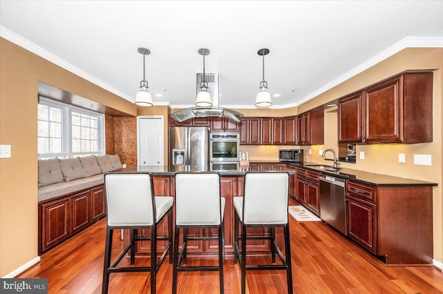 kitchen featuring stainless steel appliances, pendant lighting, a center island, and sink