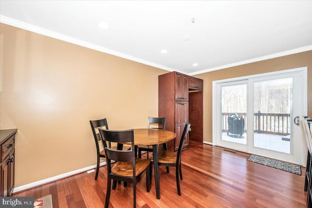 dining room featuring hardwood / wood-style flooring and crown molding