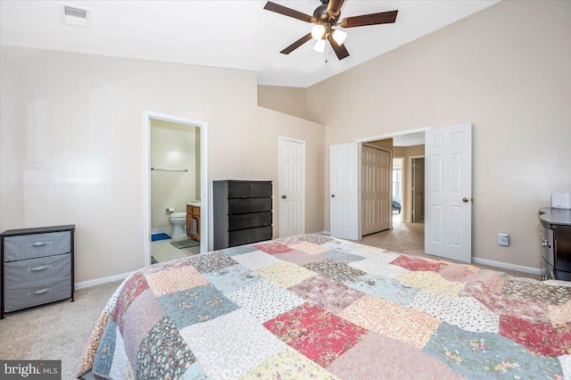 carpeted bedroom with vaulted ceiling, connected bathroom, and ceiling fan