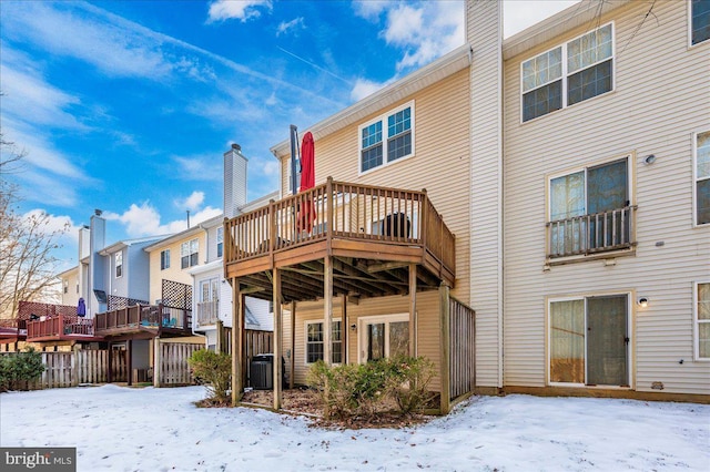 snow covered rear of property with central AC unit