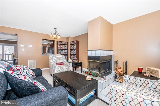 living room with a fireplace, a chandelier, and tile patterned flooring