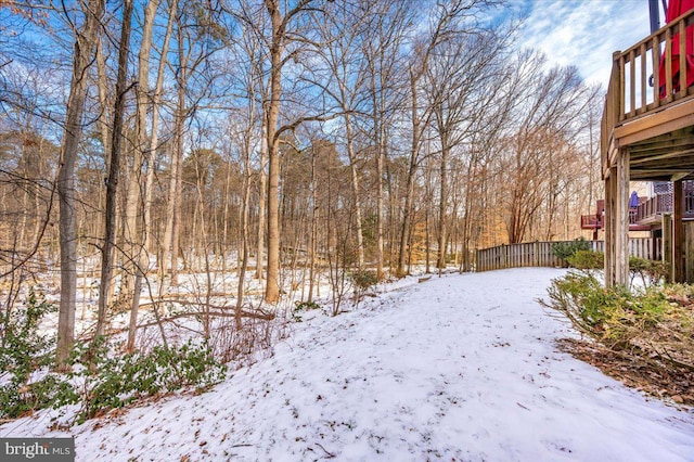 yard layered in snow with a wooden deck