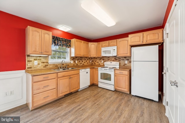 kitchen with sink, light brown cabinetry, white appliances, and light wood-type flooring