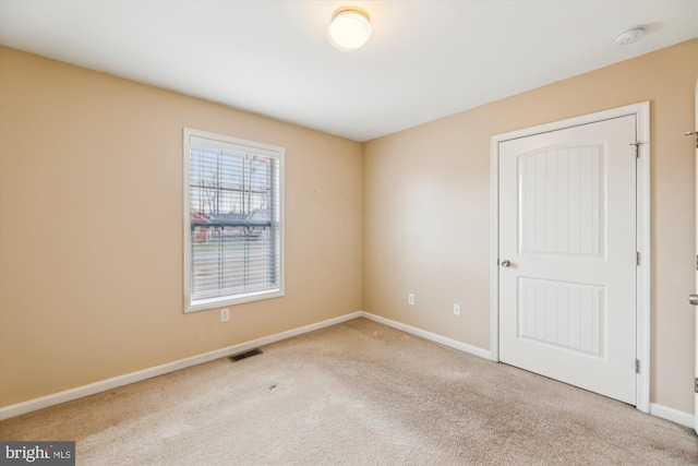 unfurnished room featuring light colored carpet