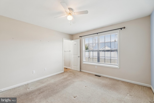 carpeted spare room featuring ceiling fan