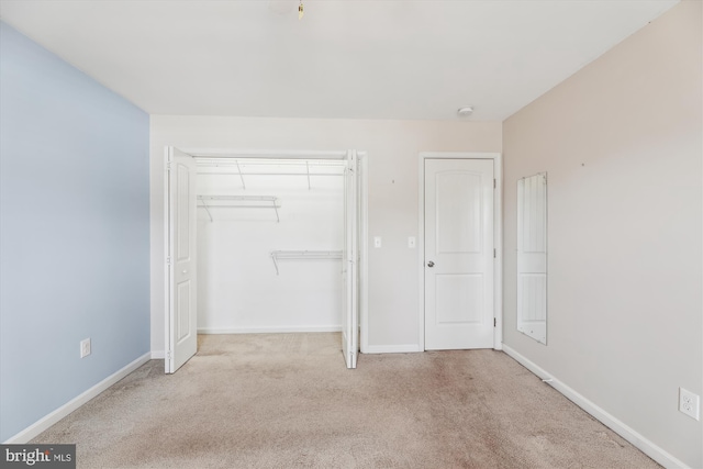 unfurnished bedroom featuring a closet and light carpet