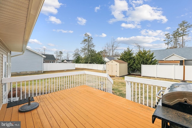 wooden deck featuring area for grilling, a yard, and a storage unit