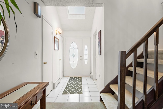 tiled foyer entrance featuring a baseboard radiator and vaulted ceiling with skylight